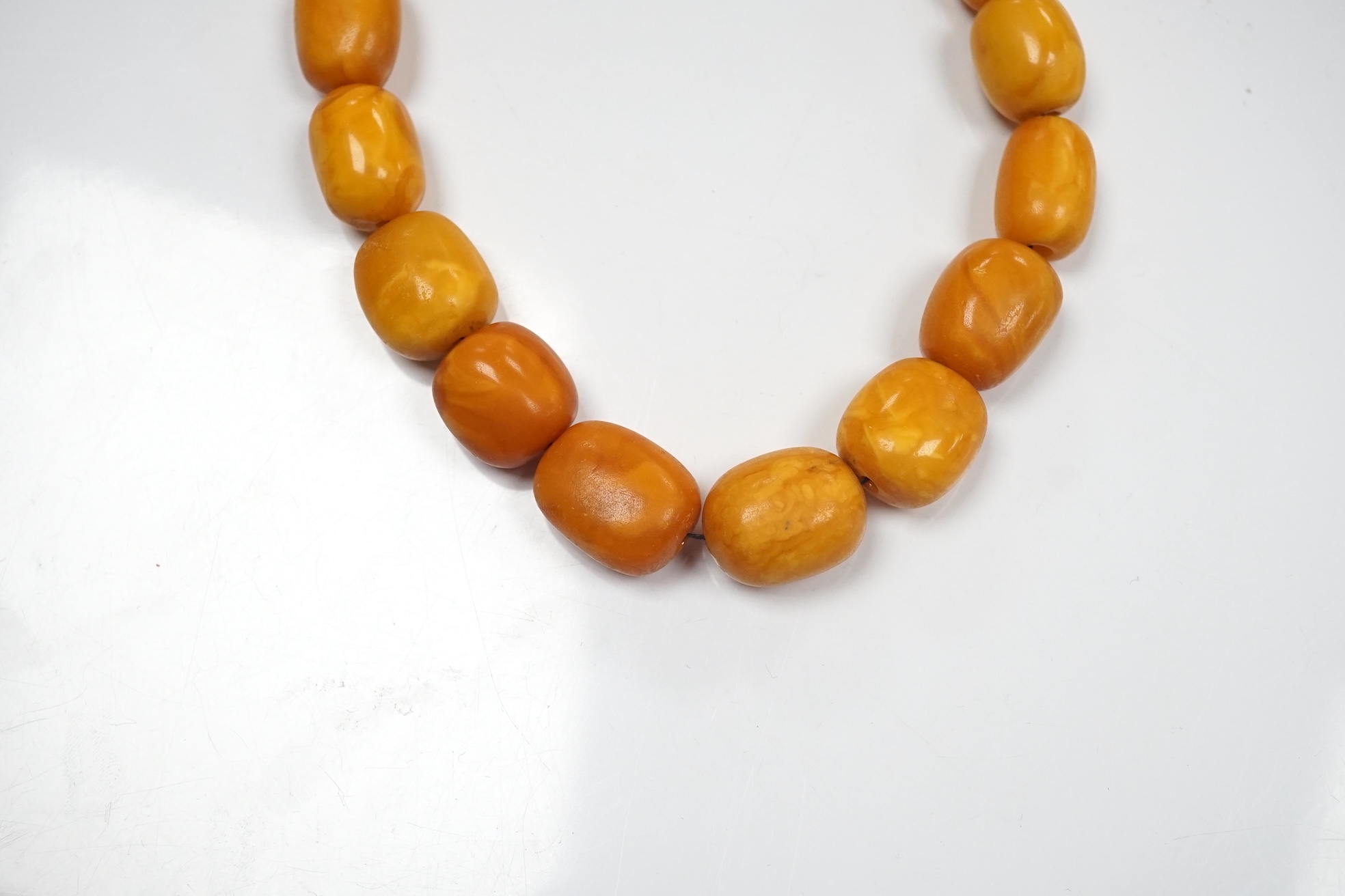 A single strand graduated oval amber bead necklace, 42cm, gross weight 49 grams. Condition - poor to fair